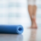 person walking in yoga studio and yoga mat