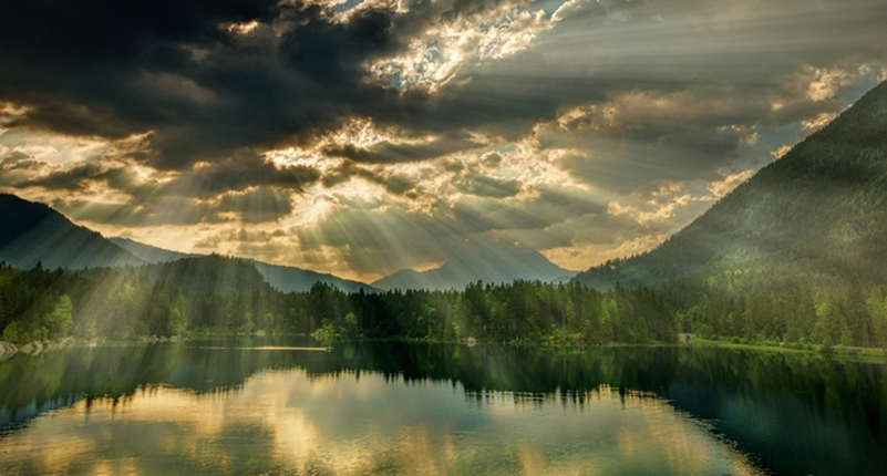 Sunset over lake with trees around the shoreline